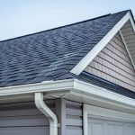 Low-angle view of a Canadian suburban home showing asphalt shingles and roof eaves under soft overcast daylight.